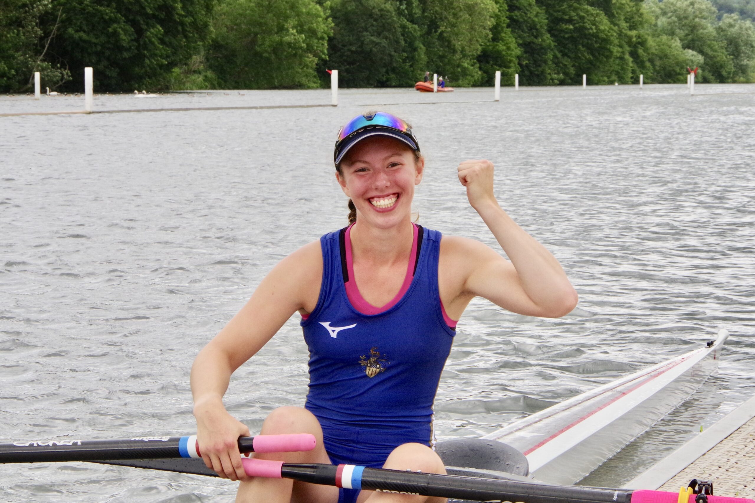 sculler raising her hand in truimph and grinning