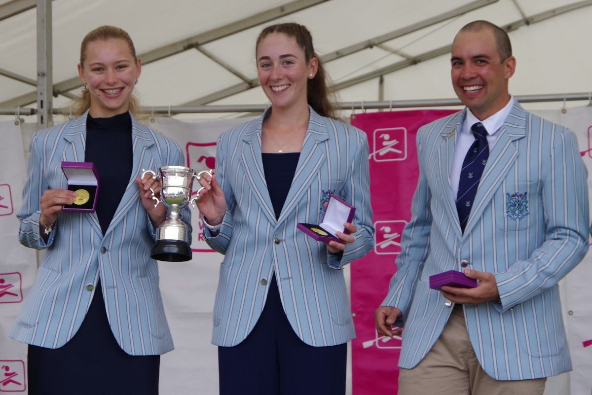 2 young women with trophies and coach