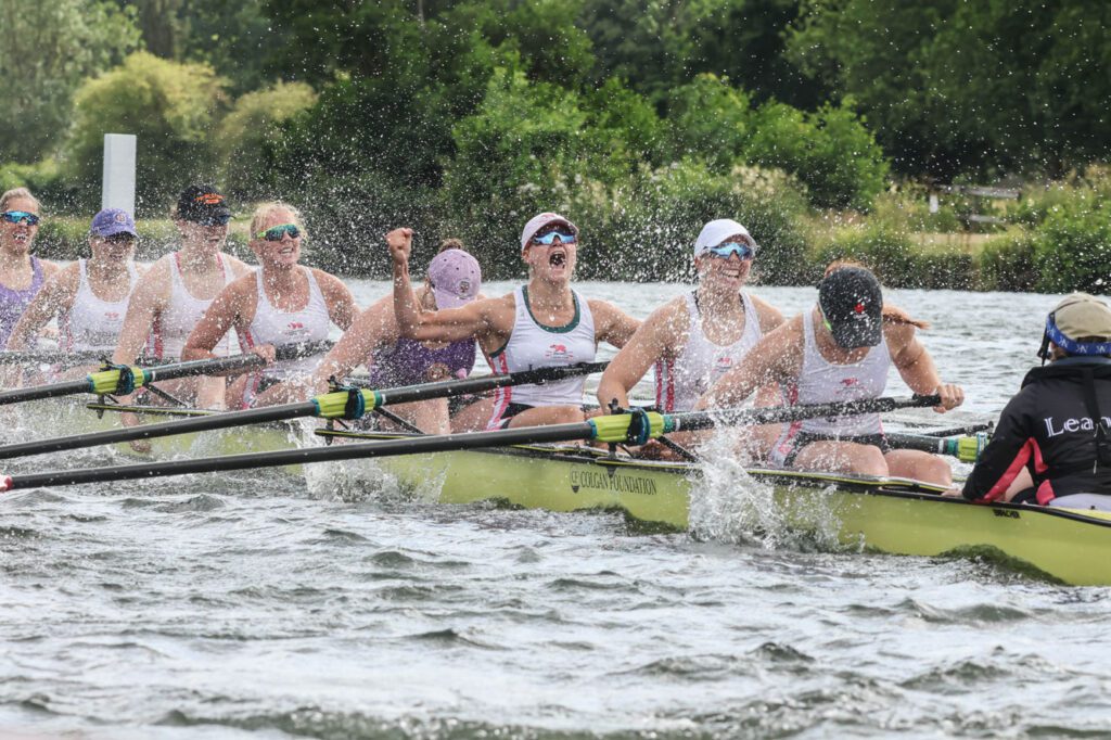Women's eight splashing water with their hands to celebrate winning