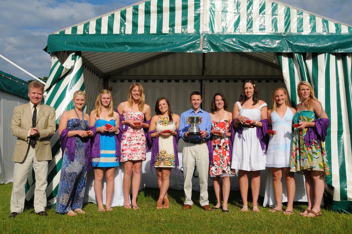 8 female rowers and a male cox with silver trophy