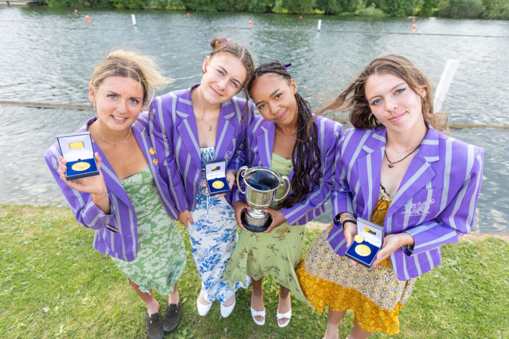 4 women in purple blazers with medals