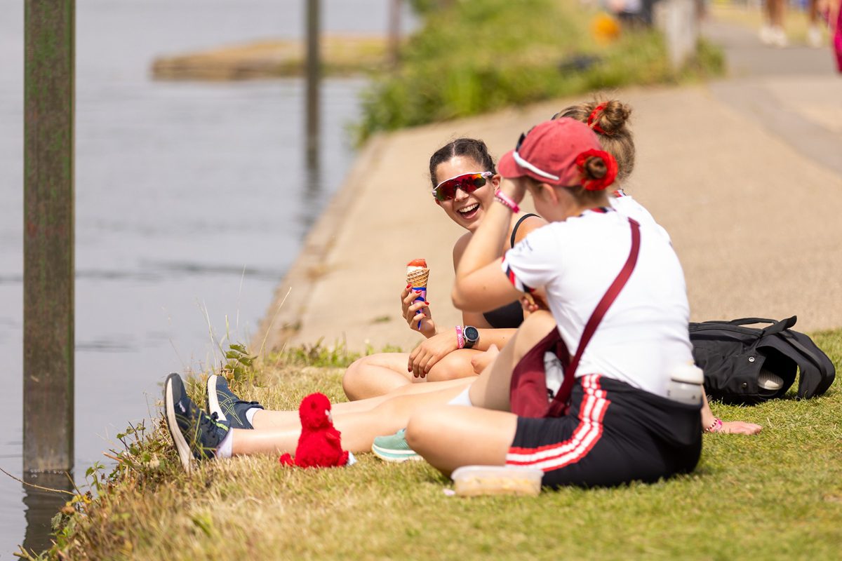 Athletes sat watching the racing in the sun