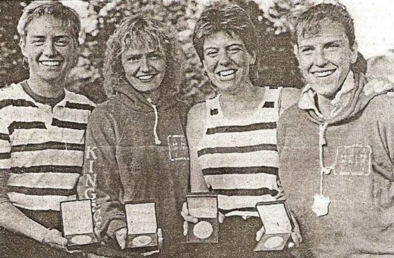 b/w photo of 4 smiling women with medals