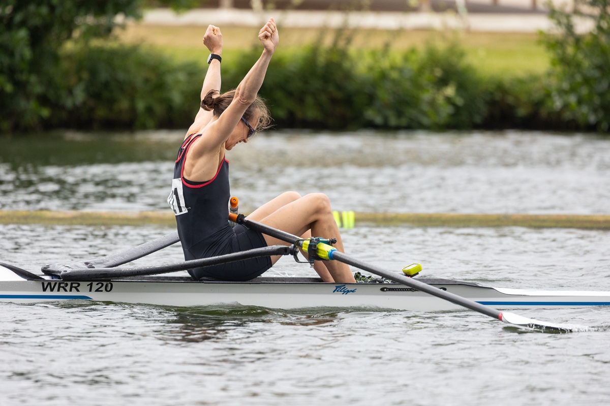 Single sculler with arms in the air celebrating success