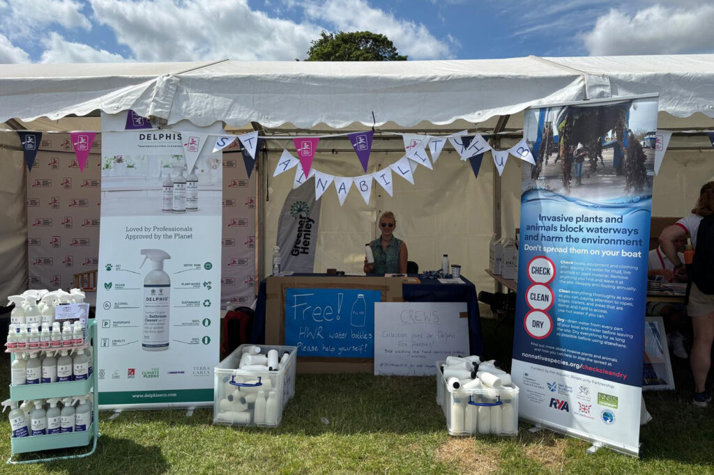 A woman is pictured in a tent surrounded by banners and signs promoting sustainability