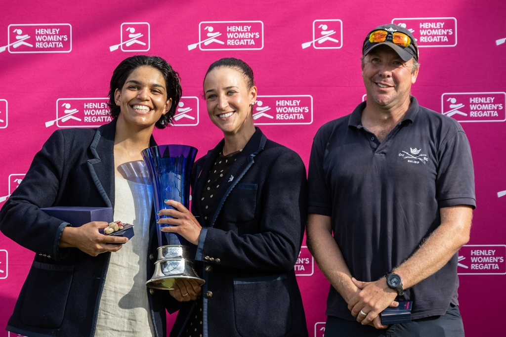 2 women with trophy and coach