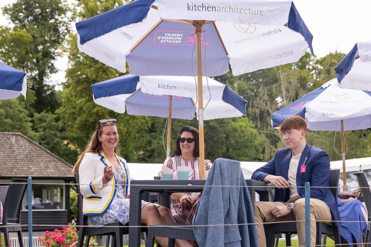 Spectators under a table umbrella in the Chairman's Enclosure